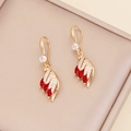 Detail of golden wing earrings with red marquise gems and crystals in a jewelry box - Earrings / Red
