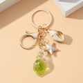 Llavero luminoso de caracola y estrella de mar con colgante sobre fondo melocotón - Verde Luminoso