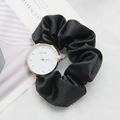 Detail of elegant watch with black silk ribbon strap and rose gold bezel on a magazine - Black