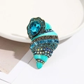 Detailed close-up of a conch shell brooch with blue enamel and sparkling crystal stones - Conch Shell Design 1
