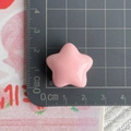 Macro view of a 2.5cm pink star resin accessory measured with a ruler for DIY crafts - Big Star / Pink