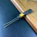 Detailed view of handmade gold wire-wrapped natural crystal on a metal hairpin - Labradorite