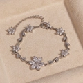 Elegantes silbernes Blumen- und Blattarmband mit Zirkon-Inlay in einer Samtbox - Blume Weißer Zirkon Platin