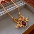 Golden bow necklace with a large red oval gemstone and sparkling diamond accents - 30# Necklace - Gold - Bowknot