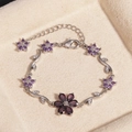Versilbertes Zweigarmband mit lila Zirkonia-Blüten auf beigem Samthintergrund - Blume Lila Zirkon Platin