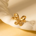 Detailed close-up of a gold hollow butterfly titanium ring on a white ceramic dish - Gold 16