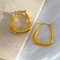 Close-up of golden irregular wave earrings on marble and silk fabric background - Gold 148/Wave shape