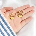 Detailed macro view of 18K gold butterfly drop earrings held on a hand for size comparison - Butterfly Shape (DE067)