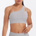 Detail of light grey one-shoulder yoga bra featuring asymmetrical cutout straps - Frost Grey