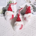 Three red knitted Christmas gnome ornaments with white faux fur beards on a soft blanket - Gnome Santa Claus / Red
