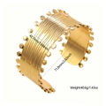 Dettaglio del bracciale rigido dorato largo con texture a onde e bordi decorati - JH040 / Oro