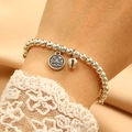 Detail of silver beaded bracelet with lion head charm and bell on woman's wrist - Silver Lion Head Bell Bracelet (X748)