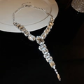 Macro della collana a Y con grandi cristalli rettangolari su un piatto bianco puro - Set collana e orecchini / Argento