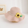 Detailed view of children's pink straw hat with yellow sunflower ornament and lace band. - Hat / Pink