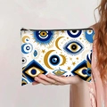 Detalle del neceser de lona con estampado de ojo turco sostenido por la mano de una modelo - Base Blanca Estrellas Y Luna Ojo Turco (jiayingpbb0431)