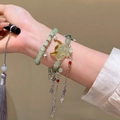 Elegant green bead bracelet with silver fox mask pendant and tassels on model's wrist - Green/Fox Mask