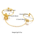 Eleganter goldener Doppelring mit Blumen und Schleifen aus Edelstahl auf weißem Hintergrund - Blumenkette Doppelring Stil