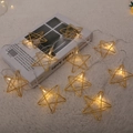 Guirnalda de luces LED de estrellas doradas con luz cálida sobre alfombra blanca - Estilo Estrella-2M 10LED