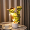Detail of LED cardinal bird potted light with warm silk flowers and white ceramic base - Lily Green Leaf Firework Light