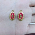Close-up of two red enamel religious medals with golden embossed Mary portraits - Red