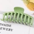 Matte green large claw clip with hollow design on an open book background - Matte Light Green