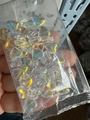 Hand holding heart-shaped transparent iridescent glass beads in a plastic bag - Half AB Iridescent