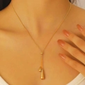 Elegante collana con doppio ciondolo a goccia d'oro indossata da una modella - Collana (8637) / Oro