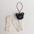 Detail eines süßen Plüschbär-Haarclip-Organizers mit cremefarbenem Fischgrätenband und Schlaufe - Schwarzer 3D-Bär