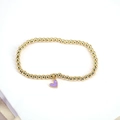 Detailansicht eines goldenen Perlenarmbands mit einem lila herzförmigen Emaille-Anhänger - Lila