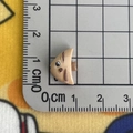 Detailed view of small beige fish resin charm measuring 1.5cm with ruler for scale - Triangle Fish