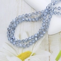 Macro shot of 6mm faceted light blue crystal glass beads on a white ceramic plate - 6mm (approx. 100pcs) / Light Blue Gray
