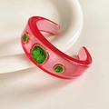 Detail view of pink resin bangle featuring green crystals and rhinestone inlay - Magenta Base with Green Zirconia