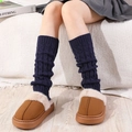 Close-up of navy blue cable knit leg warmers paired with plush faux fur house slippers - One Size / Navy Blue