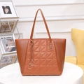 Brown quilted tote bag with triangle embroidery and gold ring pendants in stylish cafe setting - Brown