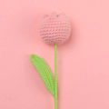 Macro shot of a pink hand-knitted tulip flower with green stem against a soft background - Korean Pink