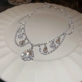 Macro shot of silver diamond choker with teardrop pendants on a white ceramic plate - Silver Water Drop Full Rhinestone Necklace