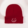 Detailed view of dark red knit beanie featuring white embroidered ghost face pattern - One Size / Burgundy