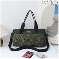 Macro detail of camouflage gym bag featuring dual handles and fashion logo patch - Green