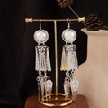Detail of silver bohemian tassel earrings with geometric leaf pendants on a display stand - Semicircle Leaf Tassel Style E2874-39