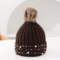 Detail view of winter knit beanie showing dark brown fabric with pearls and faux fur pom - One Size / Coffee