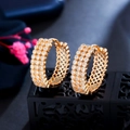 Elegant gold-plated hoop earrings inlaid with sparkling zircon on a professional display stand - Gold
