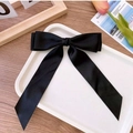 Elegant large black satin bow hair clip with long ribbons on a white tray display - Black