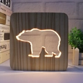 3D wooden night light with a hollow bear silhouette and warm LED glow on a desk - Polar Bear/15cm