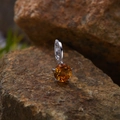 Macro shot of silver pendant with faceted orange gemstone on natural brown rock - Natural Citrine Round Pendant Silver