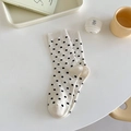Cremeweiße Söckchen mit schwarzen Punkten in einer gemütlichen Lifestyle-Atmosphäre - Gepunktet Beige