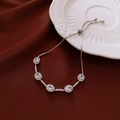 Detail of adjustable silver flower bracelet with five zircons on a white ceramic plate - Silver Tone White Oval Adjustable Slider Style