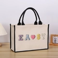 Close-up of canvas tote bag with easy letter embroidery and pink heart detail - EASY