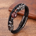 Detailed view of dragon head charms on a black braided leather bracelet with a red bead - Dragon Head Red Tiger Eye