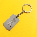 Silver stainless steel keychain with letter X cutout pendant on a yellow background - Letter X