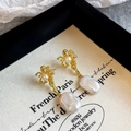 Vue détaillée des boucles d'oreilles perles baroques dorées avec texture de lave sur boîte - Or Brillant/Grosse Perle Blanche Texture Lave (NL07225E)